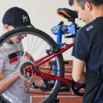 Personnes qui réparent un vélo.